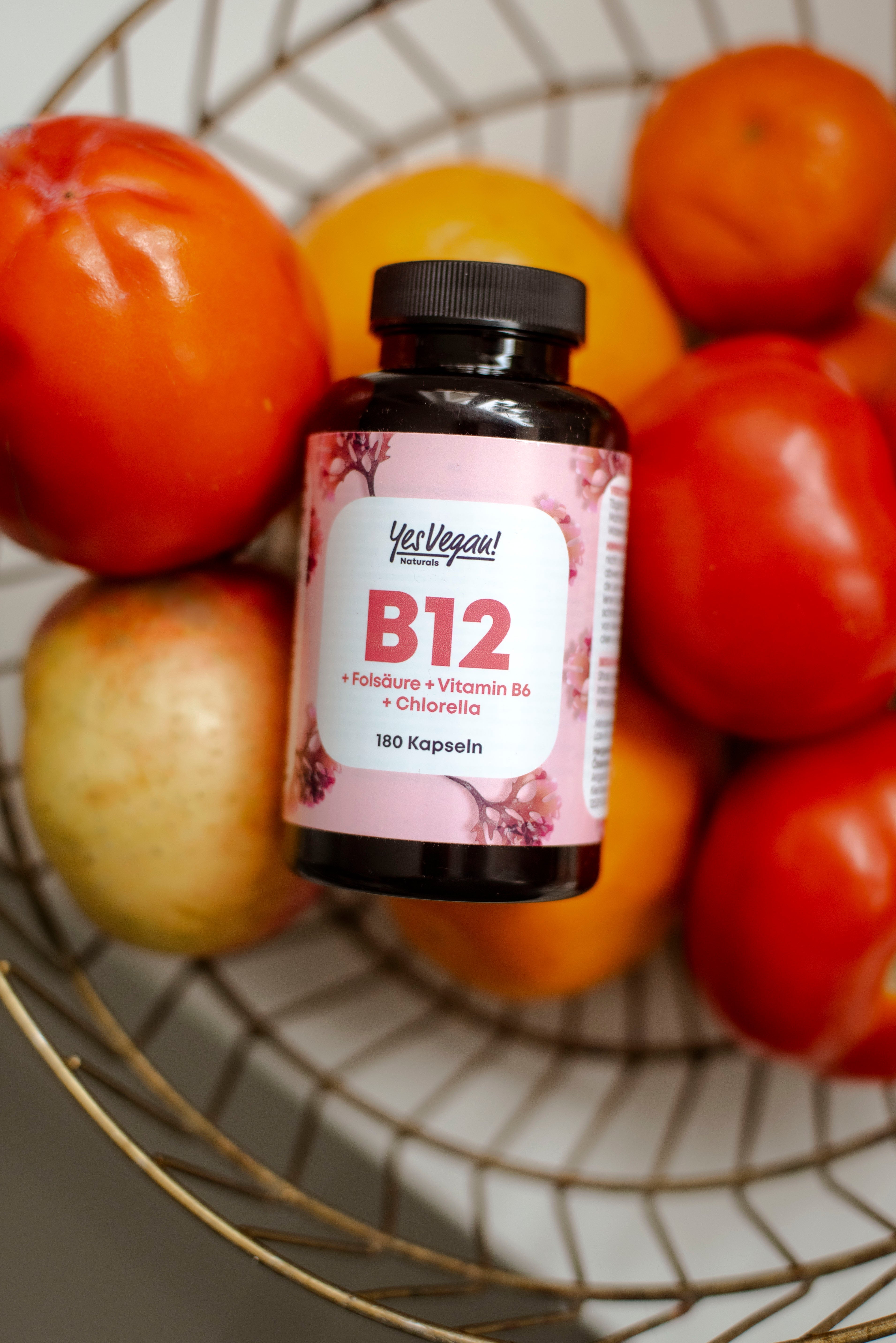 Yes Vegan Vitamin B12 Dose im Obstkorb mit Tomaten und Äpfeln