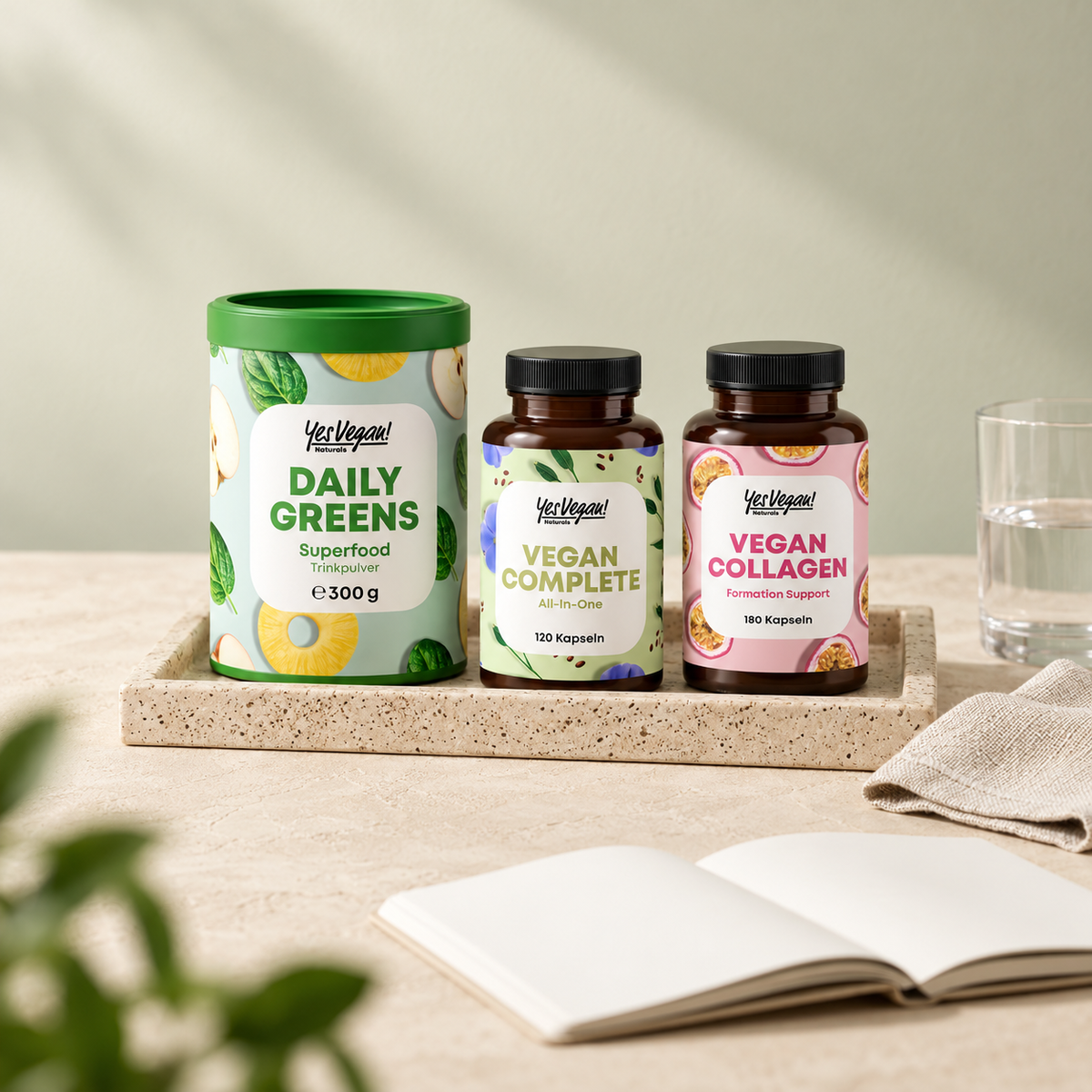Daily Greens, Vegan Complete und Vegan Collagen Kapseln auf einem Tablett