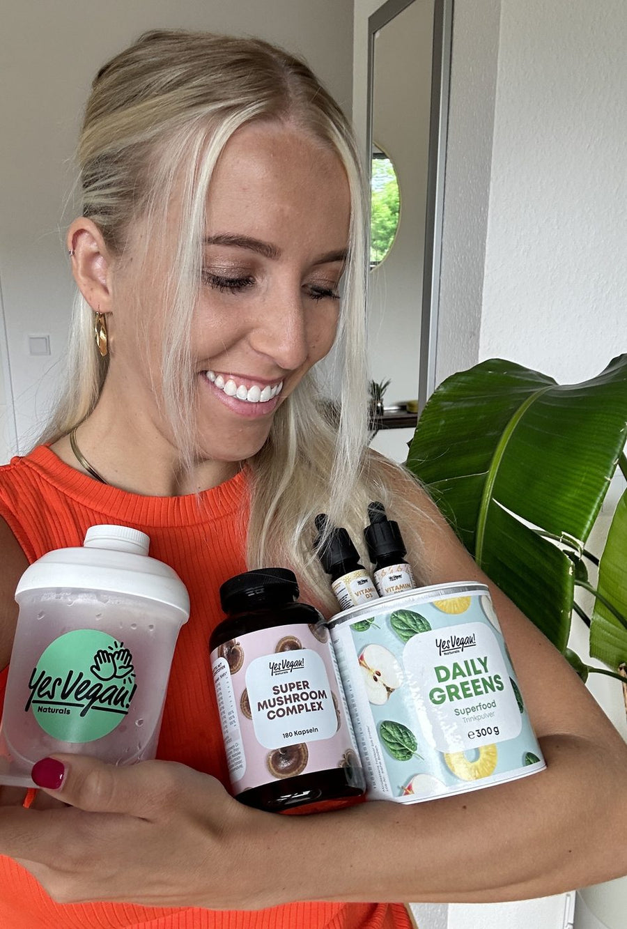Frau umarmt Yes Vegan Super Mushroom Complex, Daily Greens und Shaker